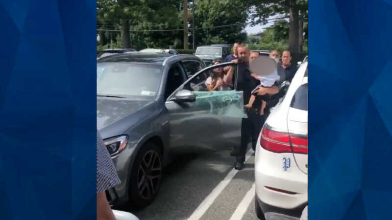 police officer carries baby from hot car
