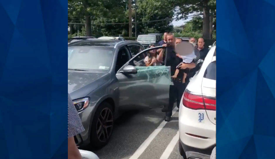 police officer carries baby from hot car