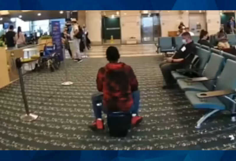 woman riding scooter through airport