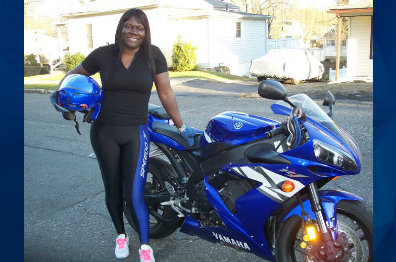 Maxine Messam standing alongside motorcycle