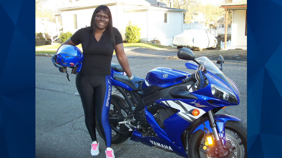 Maxine Messam standing alongside motorcycle
