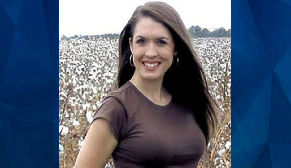 Tara Grinsted smiling, standing in front of cotton field