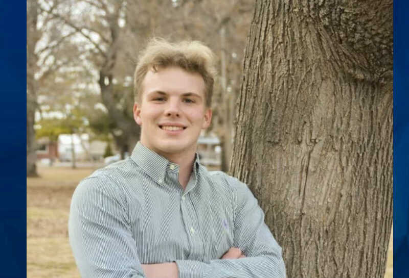 Aaron Davis standing by tree