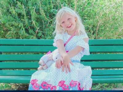 Rebekah Baptiste in white dress on green bench