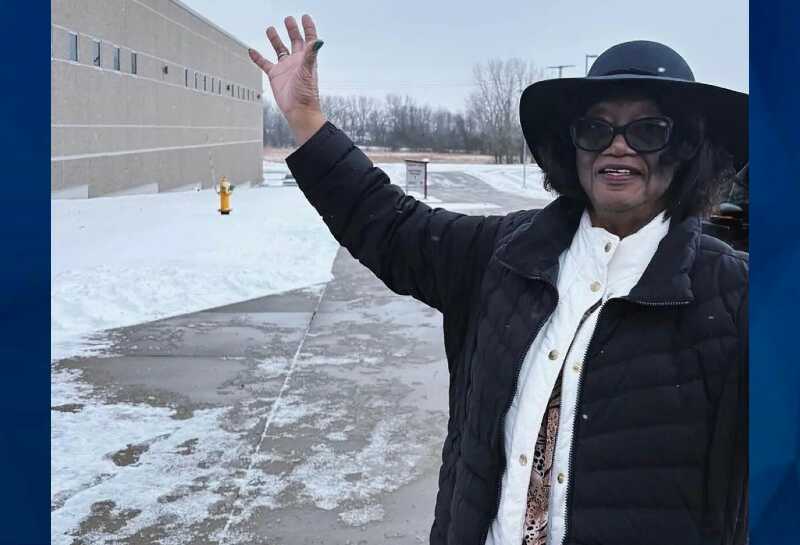 Annie Tisdale in black hat, white scarf, and black coat